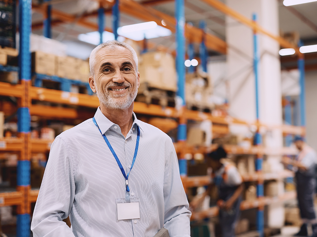 Warehouse manager smiling as he manages international shipping delays